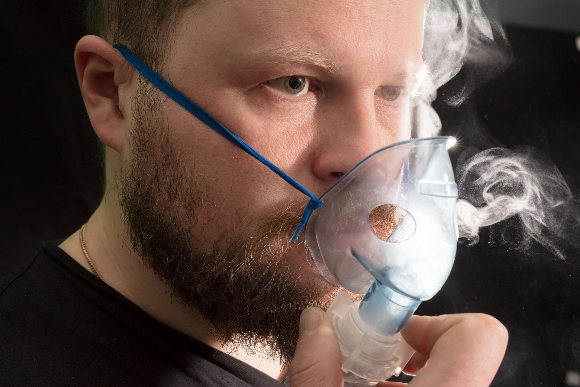 Hombre respirando máscara de nebulizador
