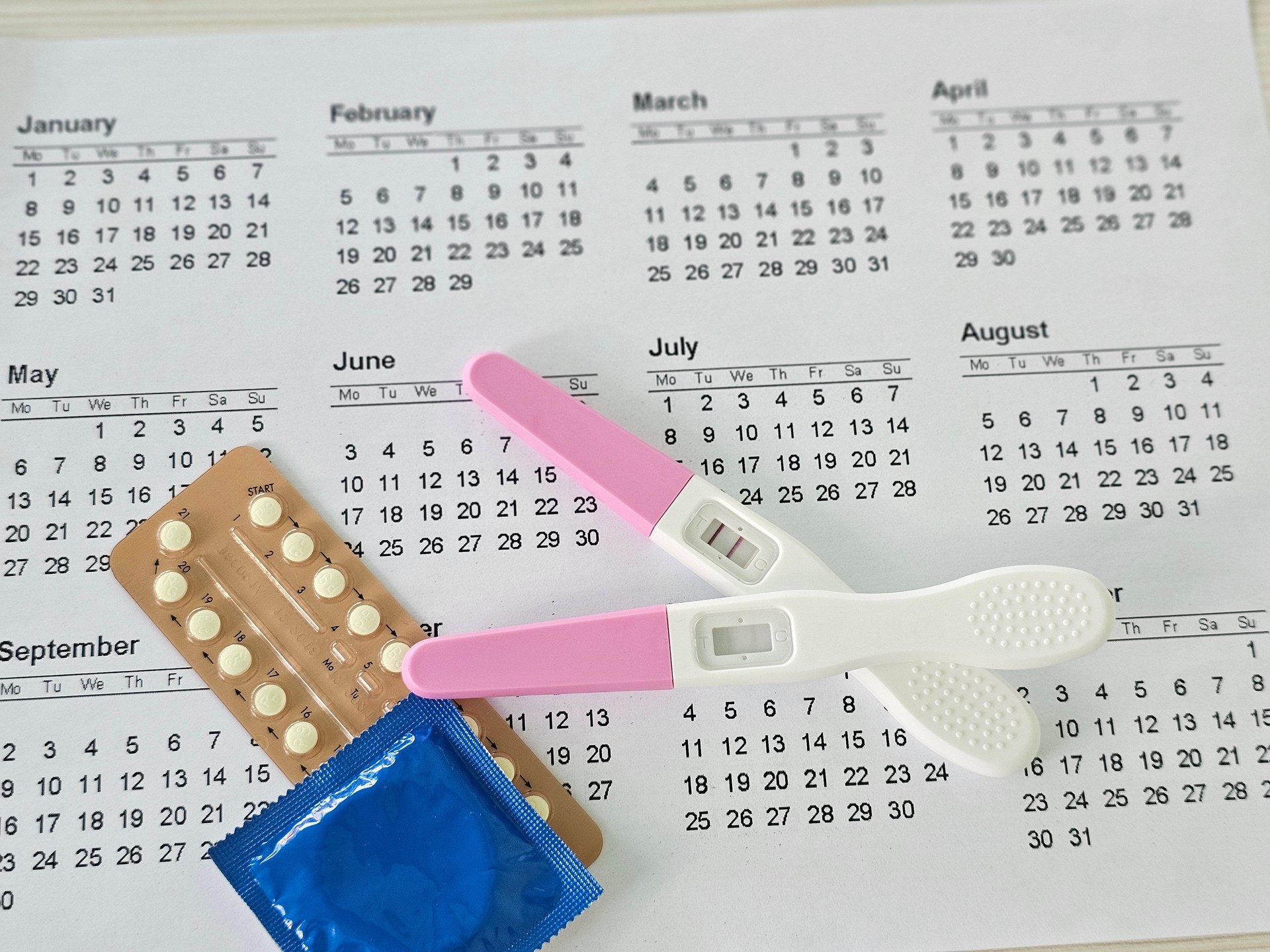 Calendario con pruebas de embarazo y métodos anticonceptivos colocados concepto