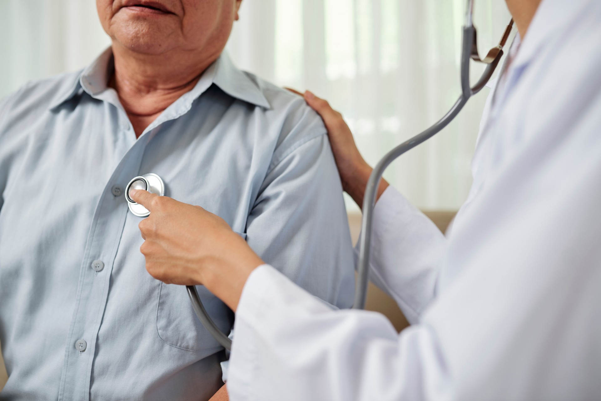 Doctor escuchando a un hombre de respiración Senior
