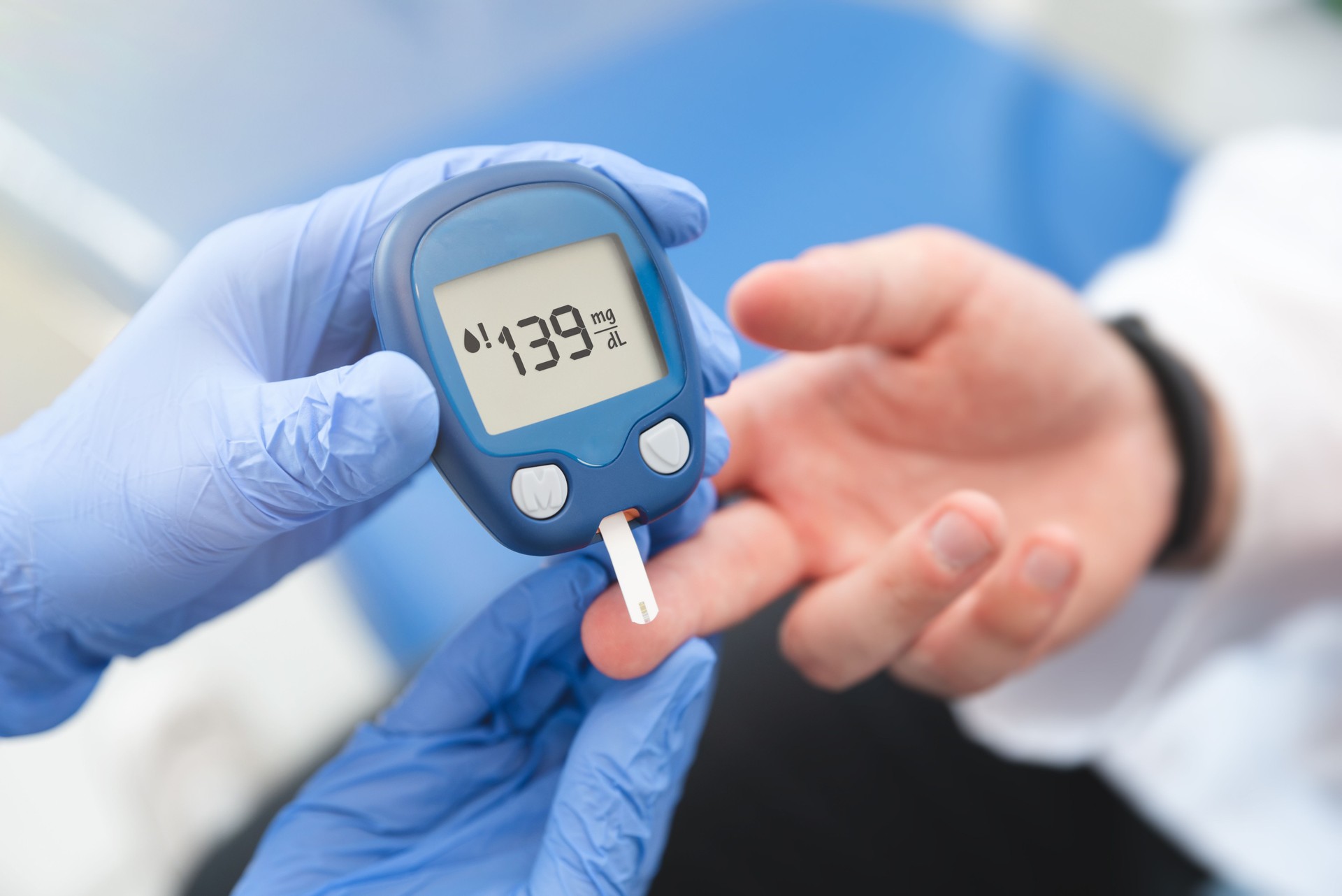 Médico usando glucómetro, prueba de glucosa en sangre