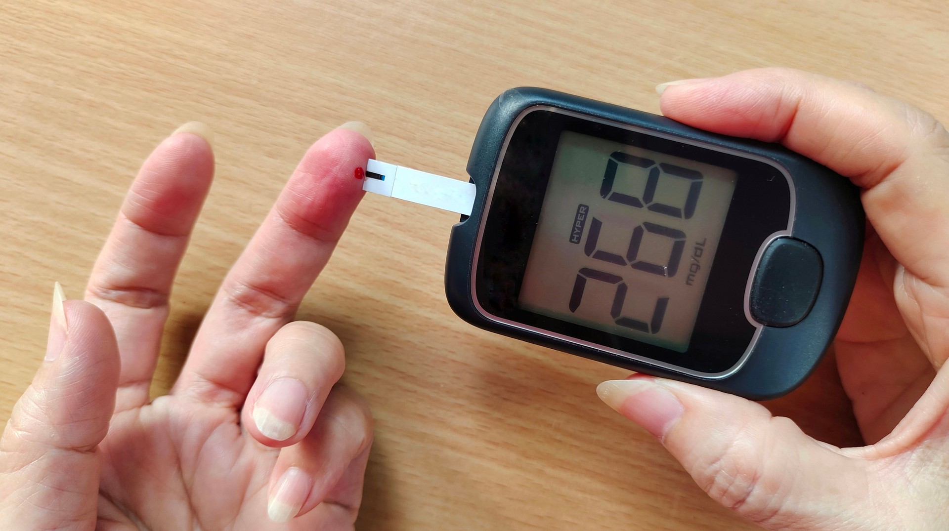 Alto nivel de azúcar en la sangre en el monitor, hiperglucemia de la mujer paciente.